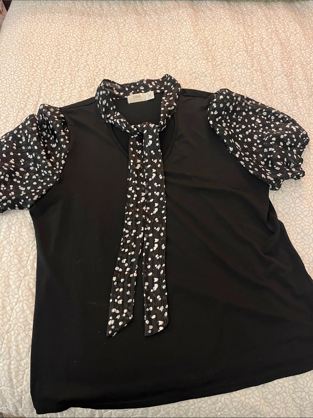 Cure Petites black and white top with sheer puff sleeves and matching accents